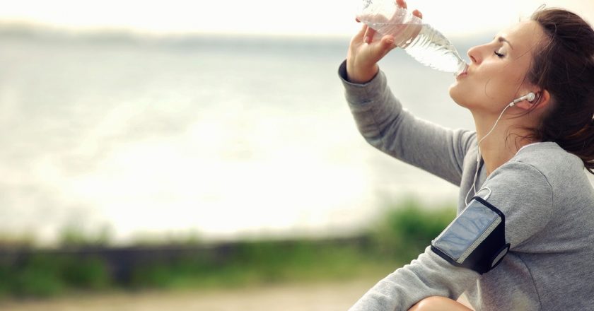 woman drinking water after excercise